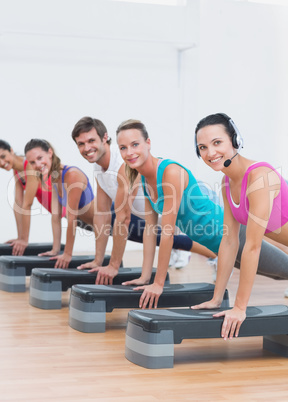 Fitness class doing step aerobics exercise