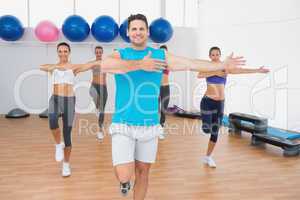Smiling people doing power fitness exercise in fitness studio