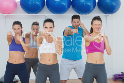 Smiling people doing power fitness exercise at yoga class