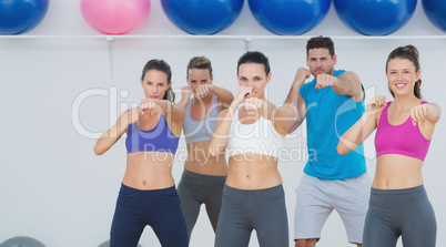 Smiling people doing power fitness exercise at yoga class