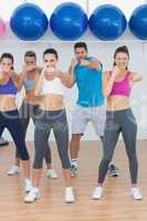 Smiling people doing power fitness exercise at yoga class