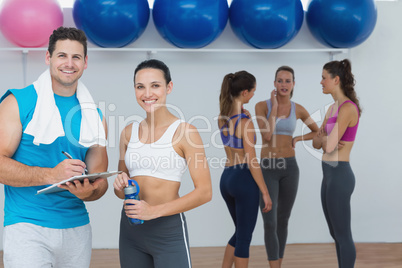 Smiling couple with fitness class in background