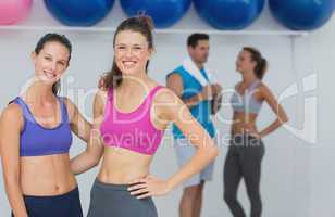 Fit women in sports bra with a couple in background