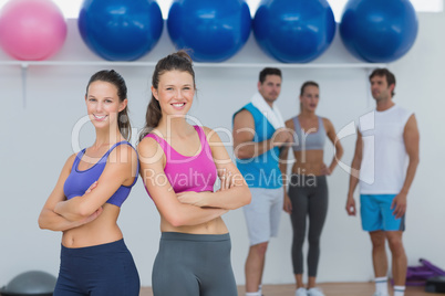 Fit women in sports bra with friends in background