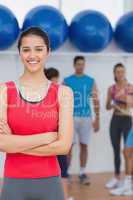 Smiling woman with friends in background at fitness studio