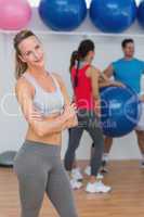 Young woman with friends in background at fitness studio