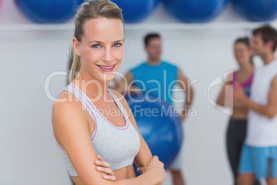 Smiling woman with friends in background at fitness studio