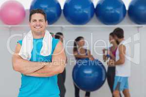 Smiling man with friends in background at fitness studio