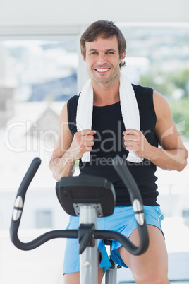 Smiling man working out at spinning class in bright gym