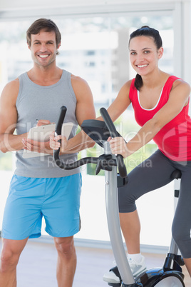 Woman with instructor working out at spinning class