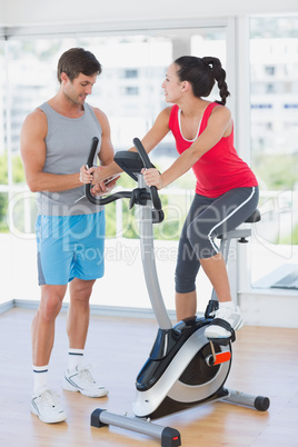 Woman with instructor working out at spinning class