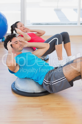 Young couple working out on dome balance