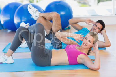 Portrait of a young couple exercising at gym