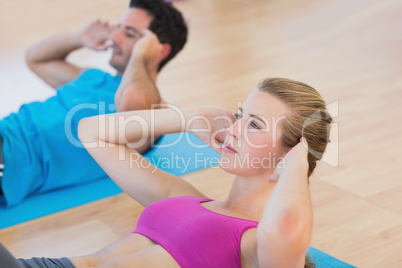 Side view of determined young couple doing sit ups