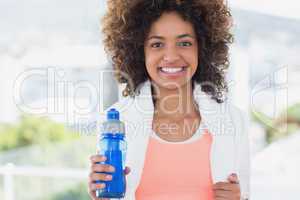 Fit young female holding water bottle at gym