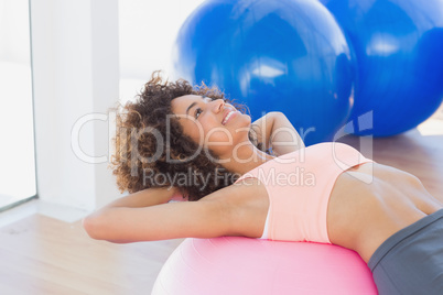 Side view of a fit woman exercising on fitness ball