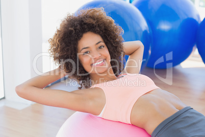 Fit young woman exercising on fitness ball