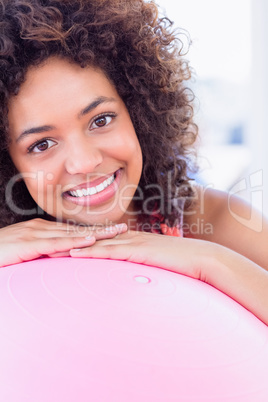 Portrait of a fit smiling young woman with fitness ball