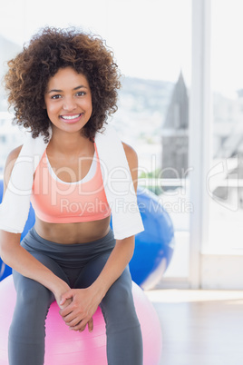 Fit young woman sitting on fitness ball at gym Fit young woman sitting on fitness ball at gym