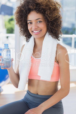 Fit young female holding water bottle at gym