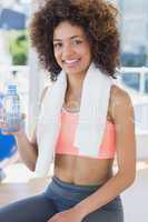 Fit young female holding water bottle at gym