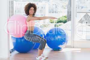 Sporty woman with exercise ball in fitness studio