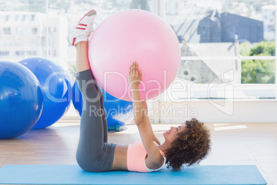 Sporty woman with exercise ball in fitness studio