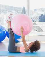 Sporty woman with exercise ball in fitness studio