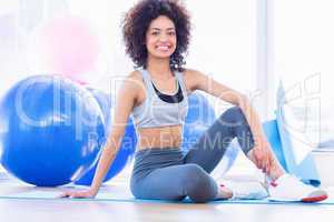 Full length of a fit woman on exercise mat in fitness studio