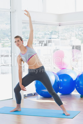 Fit woman stretching hand in fitness studio