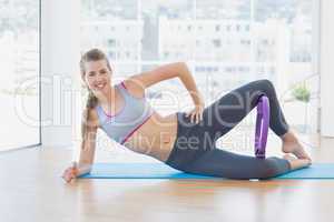 Sporty young woman with exercising ring in fitness studio