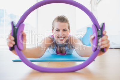 Smiling woman with exercising ring in fitness studio