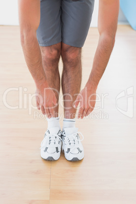 Man touching hands to feet in fitness studio