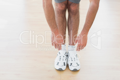 Man touching hands to feet in fitness studio