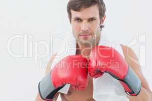 Portrait of a serious young man in red boxing gloves