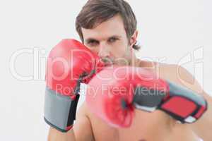 Portrait of a serious young man in red boxing gloves