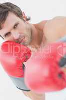 Portrait of a serious young man in red boxing gloves