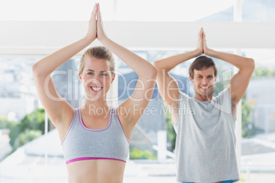 Sporty couple with joined hands in fitness studio