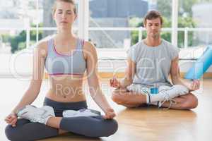 Couple in meditation pose at fitness studio