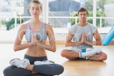 Couple in meditation pose at fitness studio