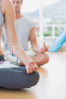 Cropped couple in meditation pose at fitness studio
