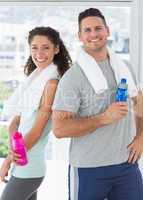 Couple holding water bottles at gym