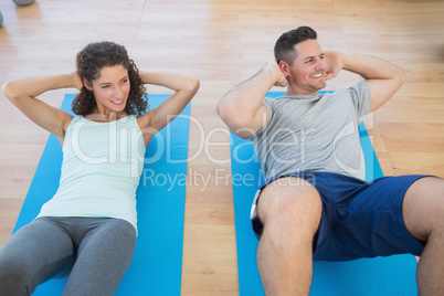 Couple doing sit ups at gym