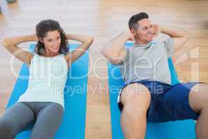 Couple doing sit ups at gym