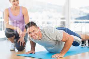Man doing push ups with female trainer