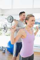 Fit woman and man lifting weights
