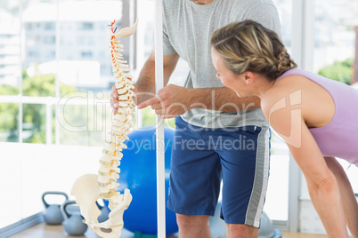 Trainer showing model of spinal cord to woman