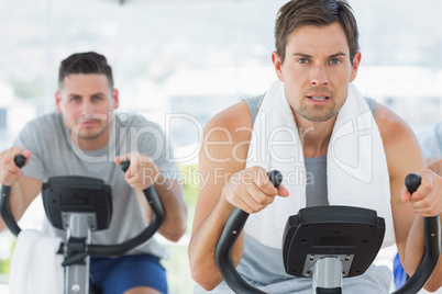 Determined men using exercise bikes Determined men using exercise bikes