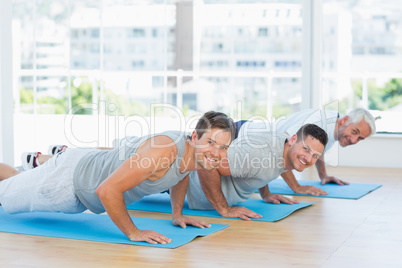Men doing push ups on exercise mats