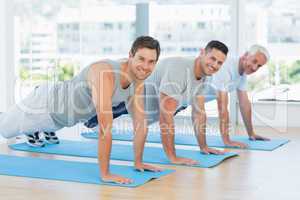 Fit men doing push ups at gym
